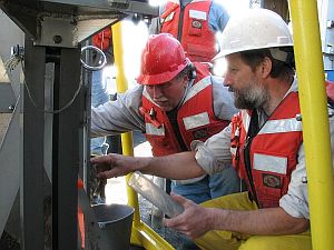 Dr. Auer and Dr. Urban examine box corer after return from bottom of Lake Superior